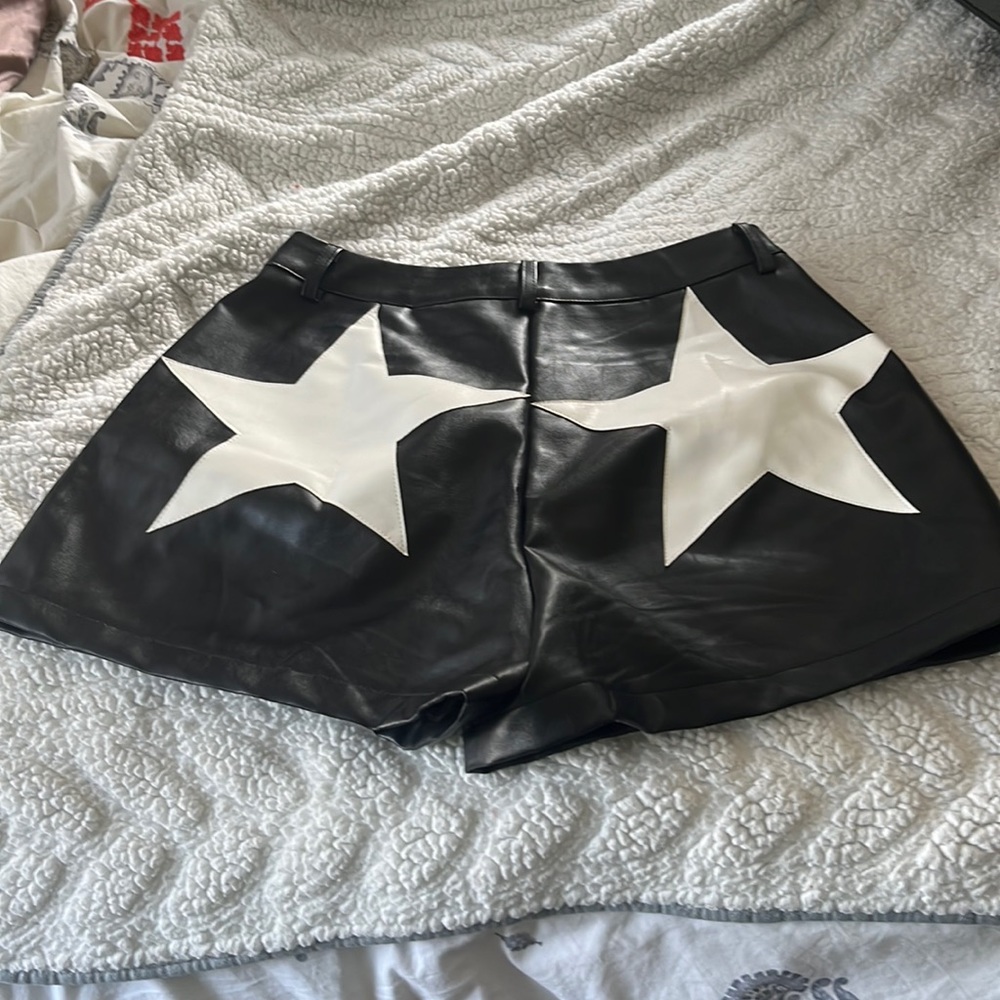 Black faux leather shorts with white stars on the back